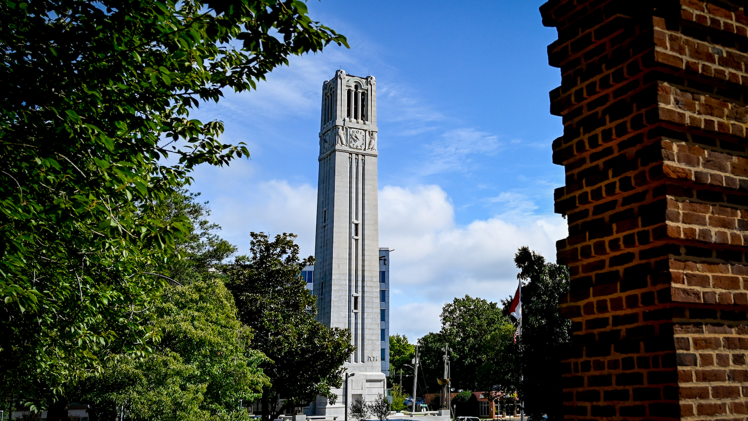 NC State Memorial Belltower with blue skies behind it.